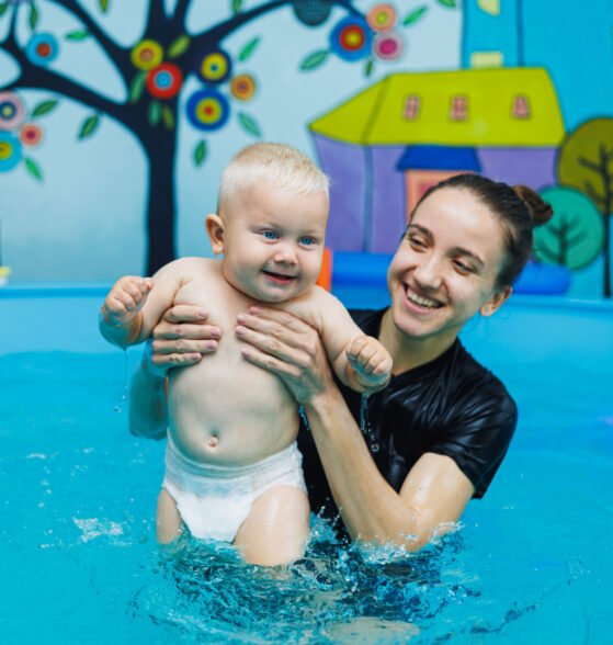 The boy has been swimming with a coach in the pool for one year. Teaching a child to swim. Swimming pool for children.